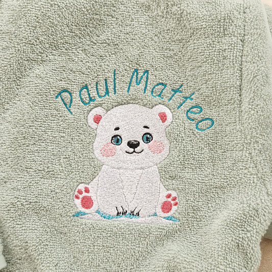 Detailaufnahme der hochwertigen Namensstickerei Paul Matteo mit Eisbär-Motiv auf einem personalisierten Baby-Bademantel in Mint.